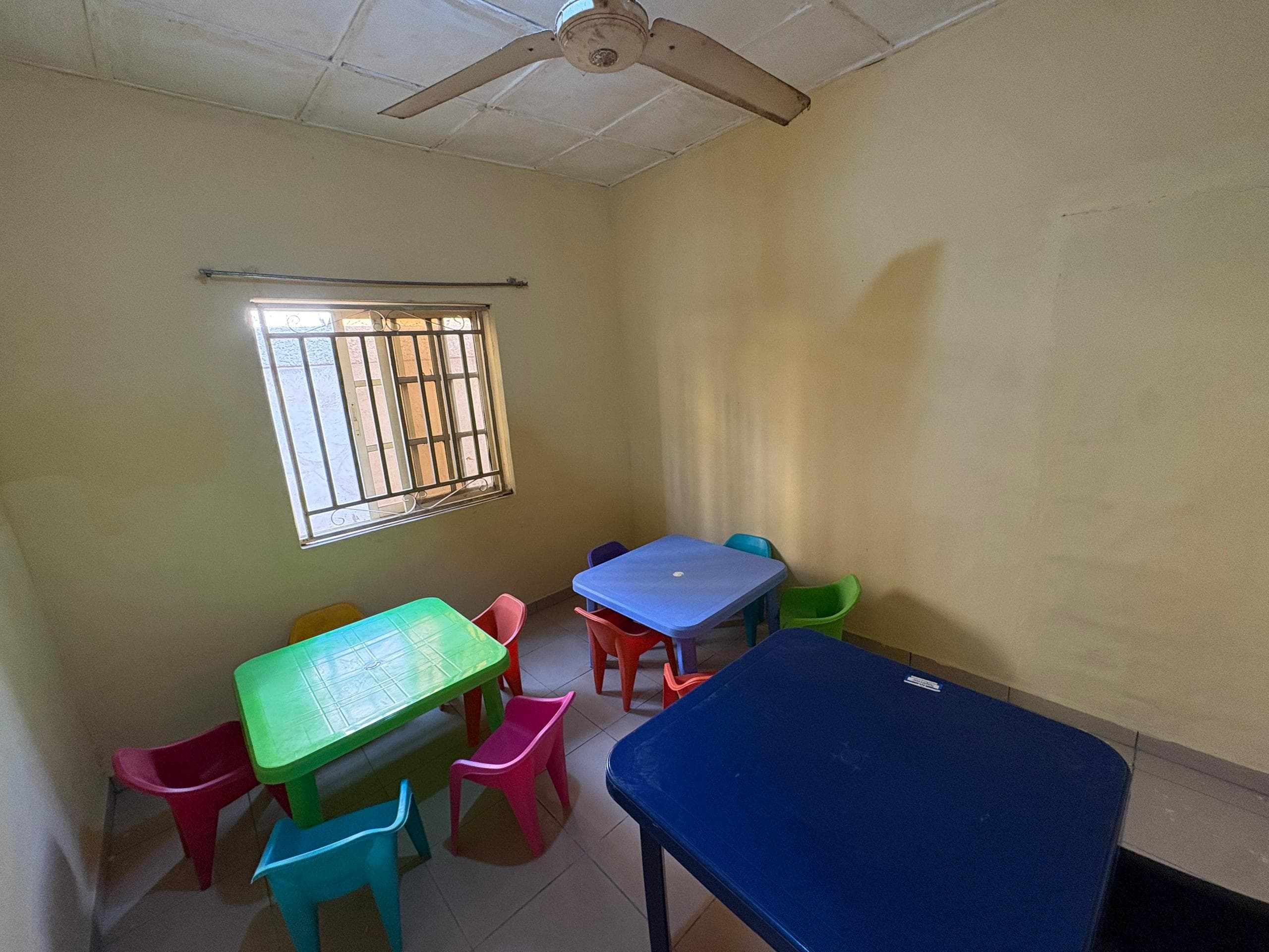 Early-years room with small colourful tables and chairs
